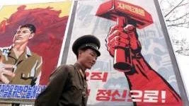 En nordkoreansk soldat framför propagandaaffischer i samband med en EU-delegations besök i maj 2001.