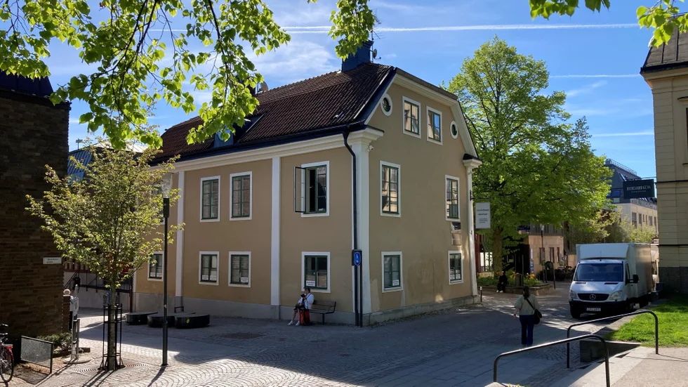 Omgiven av moderna byggnader står det gamla bostadshuset ensamt i hörnet av Apotekare- och Domkyrkogatorna. Byggnaden var den enda som bevarades i samband med det tidiga 1970-talets sanering av kvarteret Apoteket.