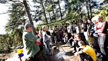 Läraren Oskar Eriksson visar eleverna hur man gör en trefoting, som de ska hänga grytan i, över elden, som de också ska göra en eldgrop till.