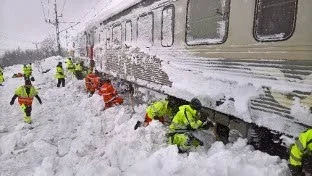 INSNÖAT. Här skottar 40 man fram det insnöade tåget.
