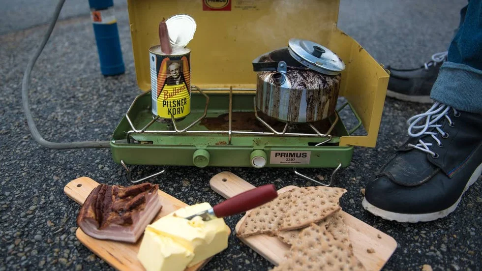 Skogsarbetarlunch. Björn Ylipää minns luncherna under sin tid som skogsarbetare; en burk med Bullens korv på gasolköket, knäckebröd, fläsk och kokkaffe.