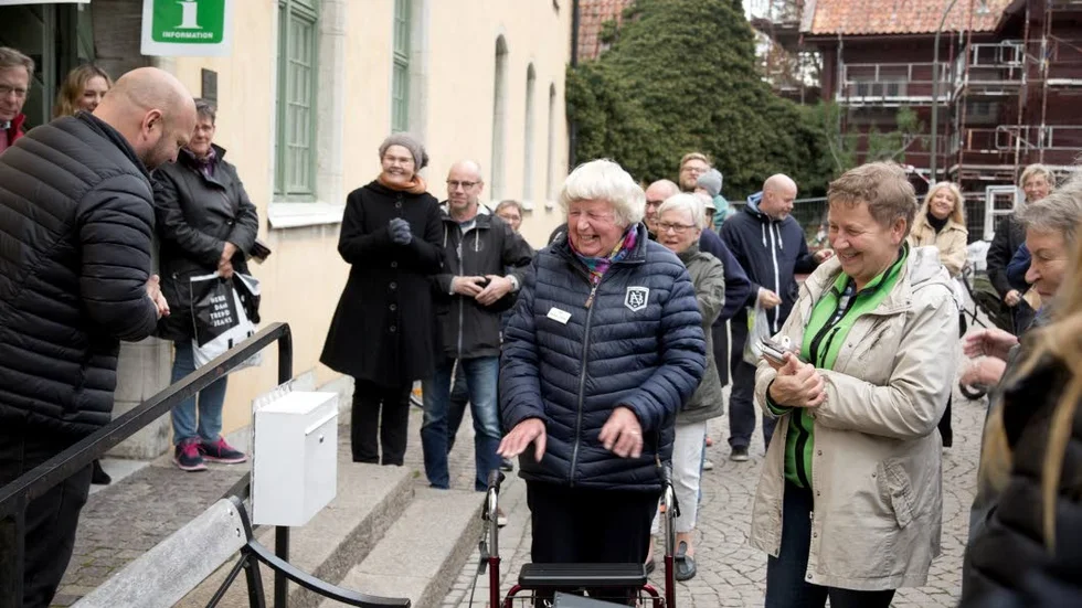 ÖVERRRASKAD. Gertrud Lyrung, som hållit stadsvandringar i 50 år, hedras med en egen bänk utanför Donnerska huset.