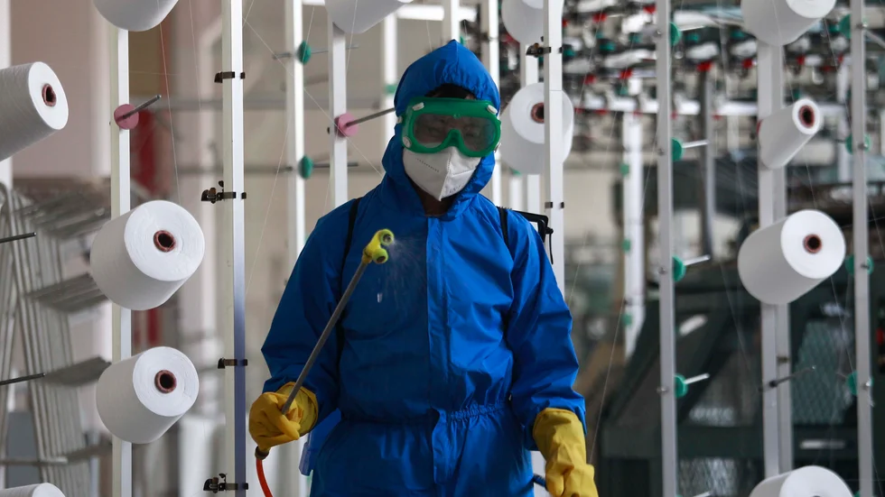 En anställd på en fabrik i Songyo-distriktet desinficerar arbetsgolvet i huvudstaden Pyongyang.