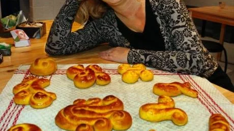 Maria Annerud, museipedagog på Fornsalen, har redan gjort julbaket och förevisar här ett tiotal olika former på det som vanligtvis kallas lussebullar.
