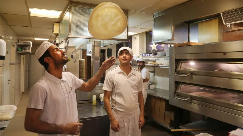Kocken Ahmed Alwaha bakar pizzor på löpande band.