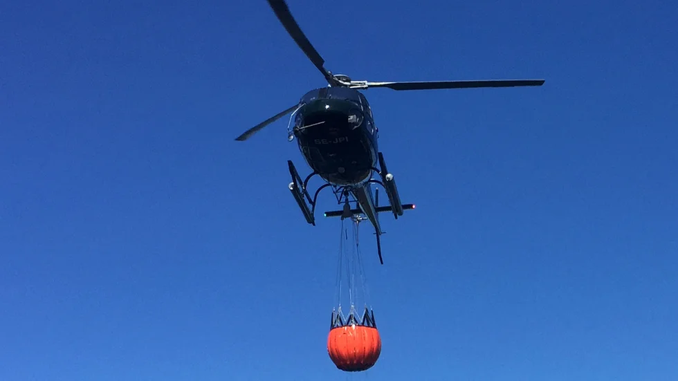 Fyra helikoptrar från MSB vattenbombade skogsbranden i Östergötland i fredags. En stulen bil antas ha satts i brand och orsakat elden, men polisen lägger ner utredningen av bilstöld. Arkivbild.