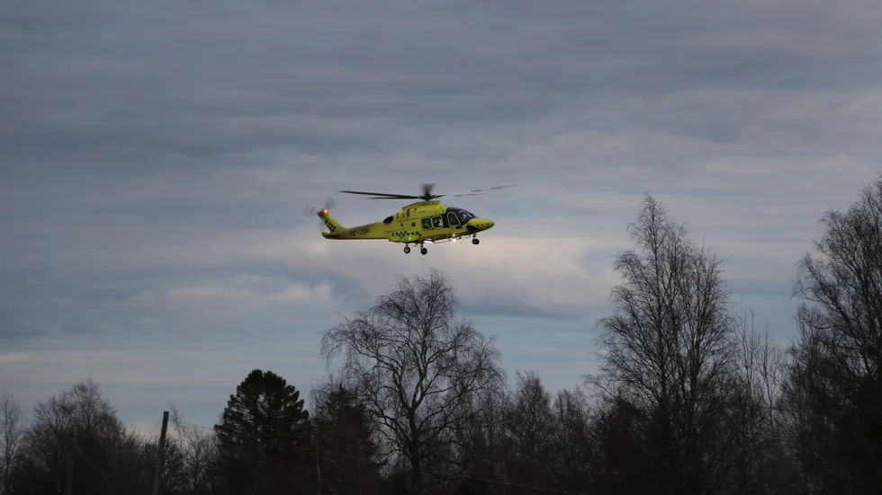 Ambulanshelikoptern på väg att landa vid mototcykelolyckan.