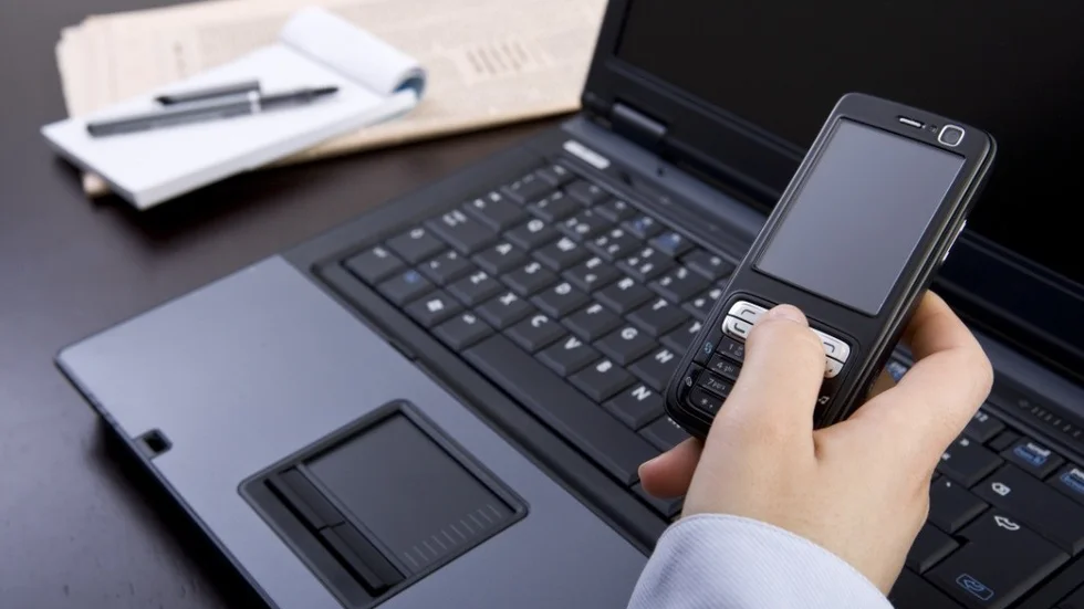 businesswoman holding mobile phone in office