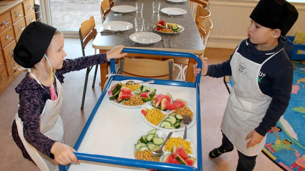 Isa Wärjerstam och Elias Berggren har hackat grönsakerna till lunchen och är på väg att köra ut tillbehören till avdelningarna där maten dukas upp.
