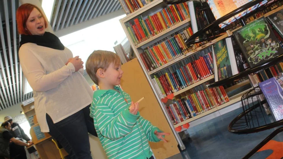 Där! Karin Fahlstedt lotsar Frank Ljung bland böcker och gömda ägg på biblioteket.