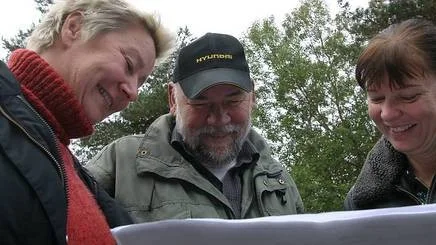 Liselott Ericsson, t h,  är glad att politikerna hörsammade hennes förslag. Här visar Ann Kärrman  från parkförvaltningen skissen för naturlekplatsen i Tallkottsparken. I mitten Boo Calson som också är med i planeringen av lekplatsen.