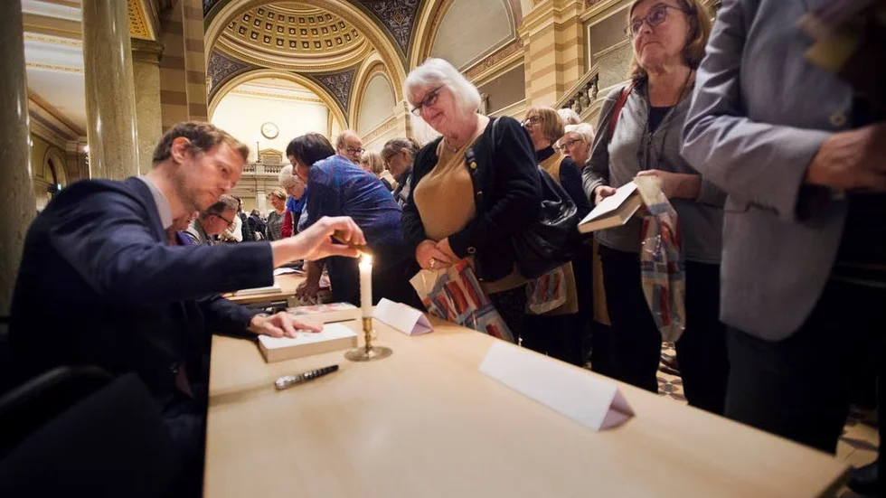 Karin Höglund får de införskaffade böckerna signerade av Niklas Natt och Dag.