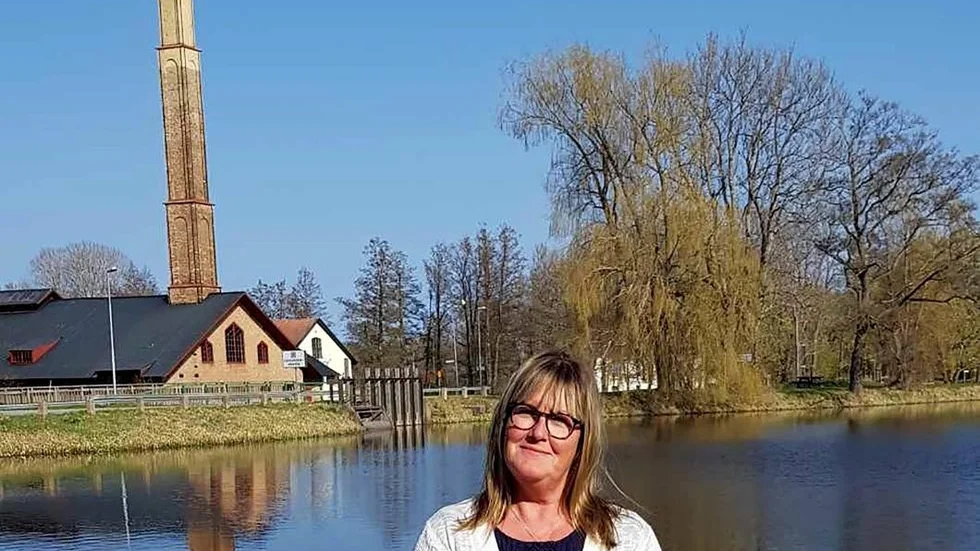 Lena Hållqvist är med och arrangerar Bruksloppisen i Kalrholmstrakten den 11 maj. Tanken är att överskottet från loppisen ska gå till en ny grillplats vid dammen i Karlholmsbruk som man ser i bakgrunden.