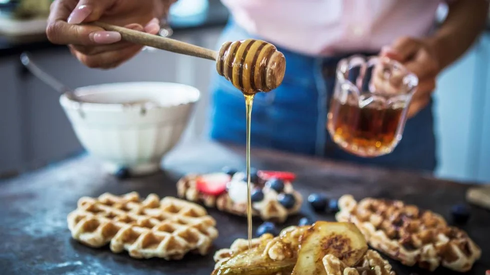 Lönnsirapen ringlas på mandelvåfflan som serveras med stekta bananer, glass och valnötter.