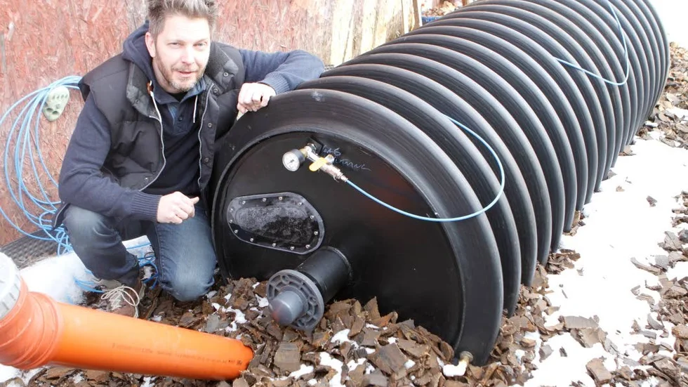 Andreas Pettersson från företaget OikosLab framför rötkammaren i avloppsystemet som nu testas i norra delen av Knivsta kommun och där näringsämnen, vatten och energi kan utvinnas lokalt.