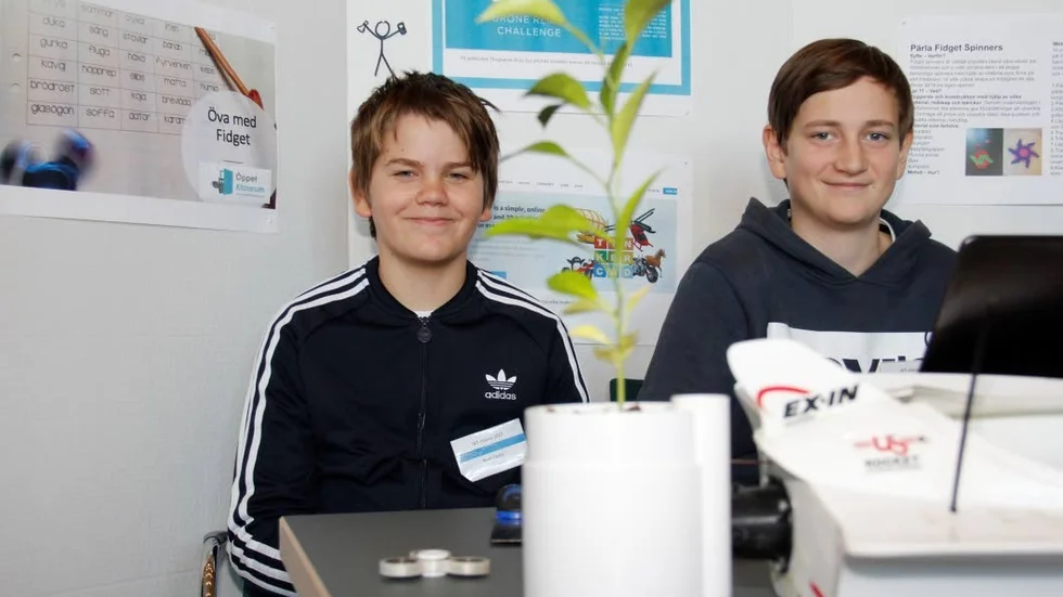Noah Castor och Hampus Ekbom  jobbar med 3D-skrivare på Alsikeskolan. Noah har printat den självvattnande krukan till apelsinplantan han drivit upp.
