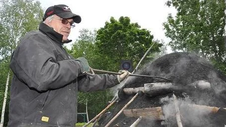 Gerhard Wahlqvist kollar hur det går med kolmilan i Hökhuvud under det sammanslagna firandet av Torer Höks dag och nationaldagen.