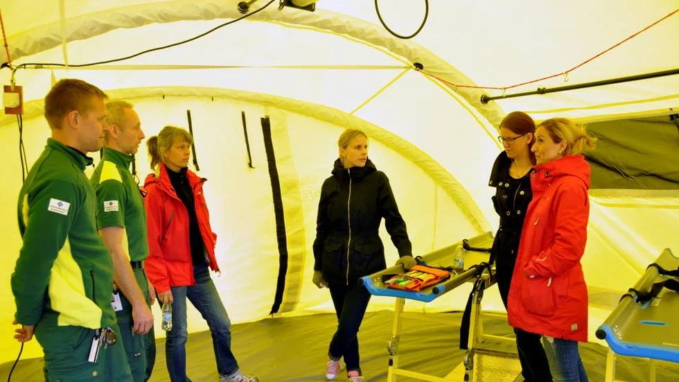 Ambulanspersonal och personal från Tierps vårdcentrum samtalar i det tält där skadade vid strörre olyckor kan vårdas.
