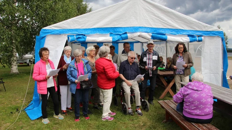 Sånggruppen med ledare Ann-Marie Wallgren, och vikarierande spelman Alf Persson någonstans i bakgrunden.