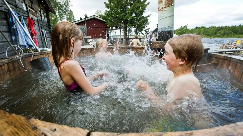 Stänk så kul det kan vara i en badtunna, visar några av de barn som också kommit för att prova på att bada bastu vid Kukkolaforsen.