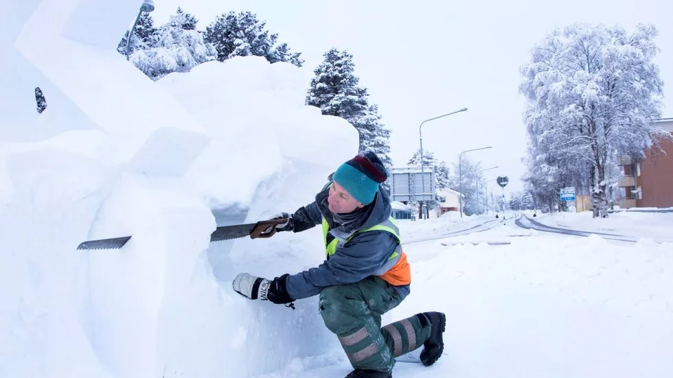 Såg och kniv är vanliga arbetsverktyg när Niclas Svensson arbetar med snöskulpturen i rondellen. Arbetet pågår från måndag till fredag veckan innan Jokkmokks marknad.