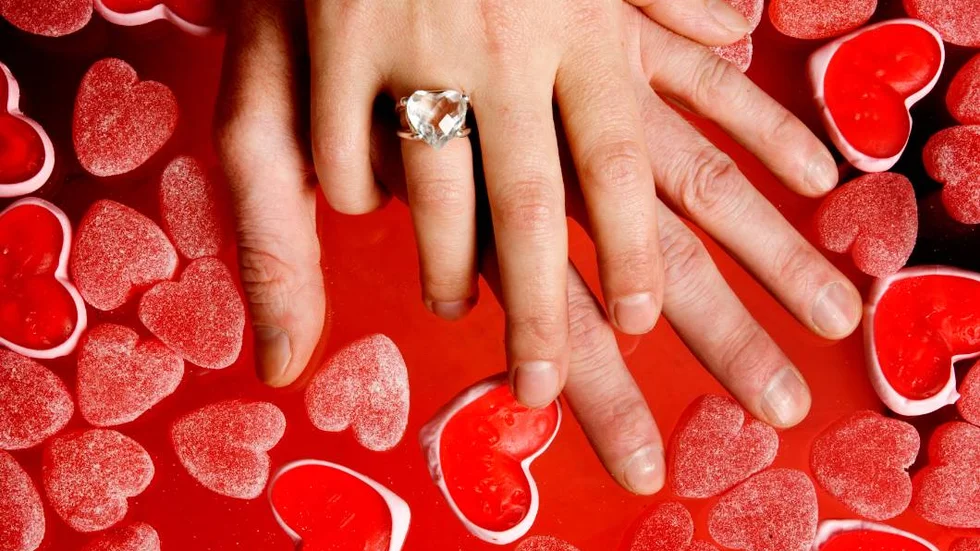 STOCKHOLM 2006-02-02 : 
Alla hjärtans dag. En man och en kvinna håller varandras händer på ett underlag av geléhjärtan. Kvinnan har en hjärtformad ring på fingret. 
Foto: Jessica Gow / SCANPIX / kod 10070