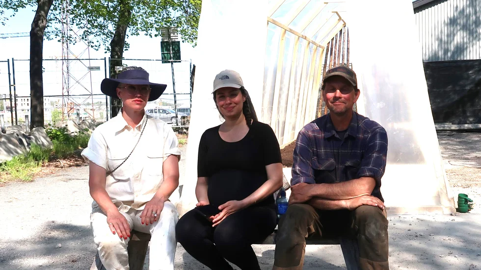 De tre konstnärerna på bänken framför det temoprära växthuset vid Södra kajen. Från vänster Åsa Jungnelius, Farvash och Markus Vallien. 