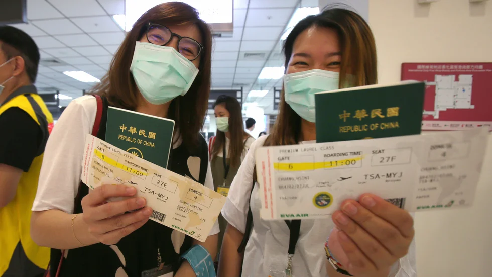 Resenärer håller upp sina taiwanesiska pass.