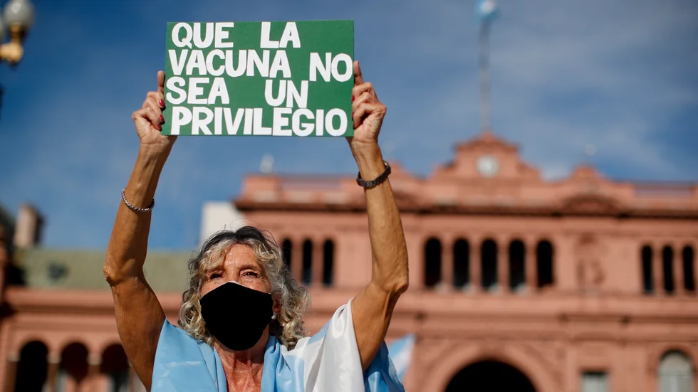 "Vaccin får inte vara ett privilegium", står det på ett av plakaten bland demonstranterna utanför regeringshögkvarteret i Buenos Aires.