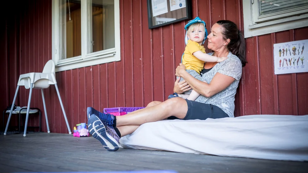 Noel Larsson Svedling, 1,5 år, och Hilde Godtlibsen, pedagog, tar en paus skuggan under taket på förskolan när temperaturen närmar sig 25 grader. 