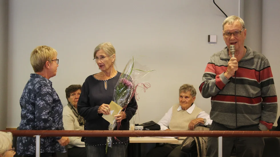PRO:s nye ordförande Kurt Vikberg, tackar avgående ordföranden Elisabeth Schoede för hennes insats. Till vänster Laila Ringqvist som lämnade blommorna.