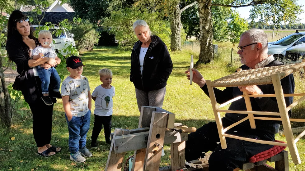Bernt Rudholm visar hur man täljer i trä och vad man kan göra av träbitar. De som tittar är Ida Olofsson med barnen Theo, ett år, Oliver Niord, fem år, Ludvig, fyra år och sin mamma Sofie Olofsson. 
