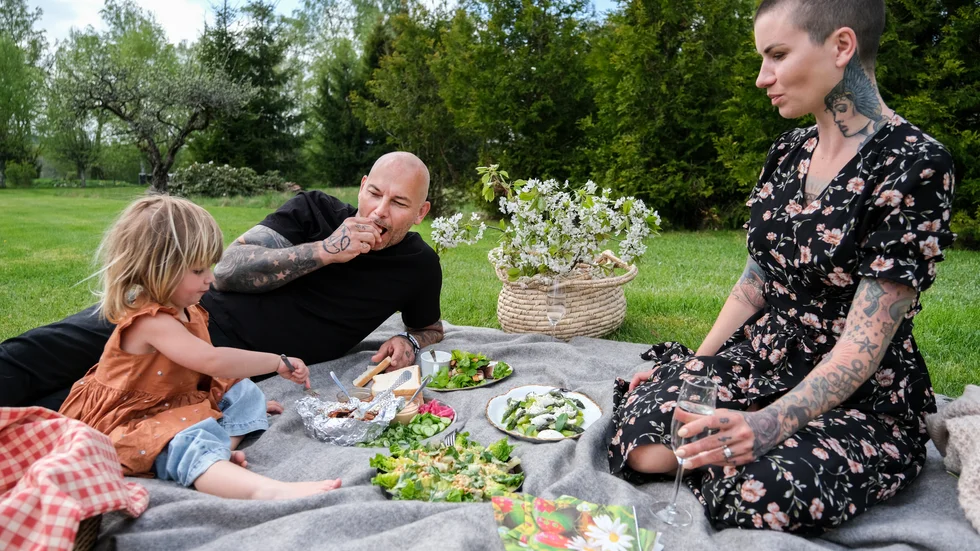 Jonas och Pia Dahlbom med dottern Liv hugger in på picknickmaten i trädgården utanför Ljungsbro.