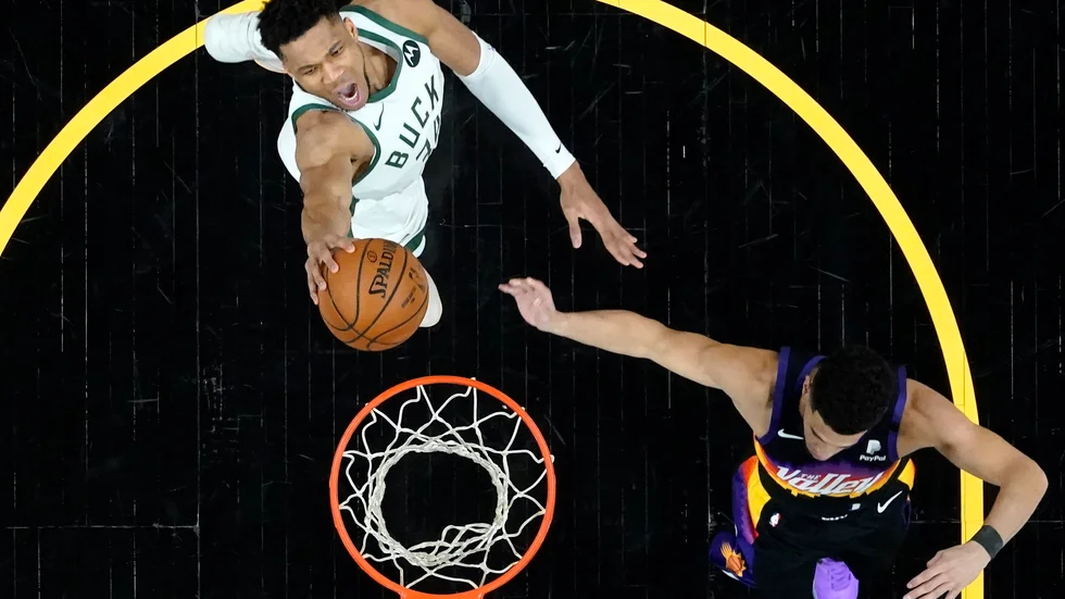 Milwaukees Giannis Antetokounmpo och Phoenix Devin Booker kämpar under korgen i den andra NBA-finalen.