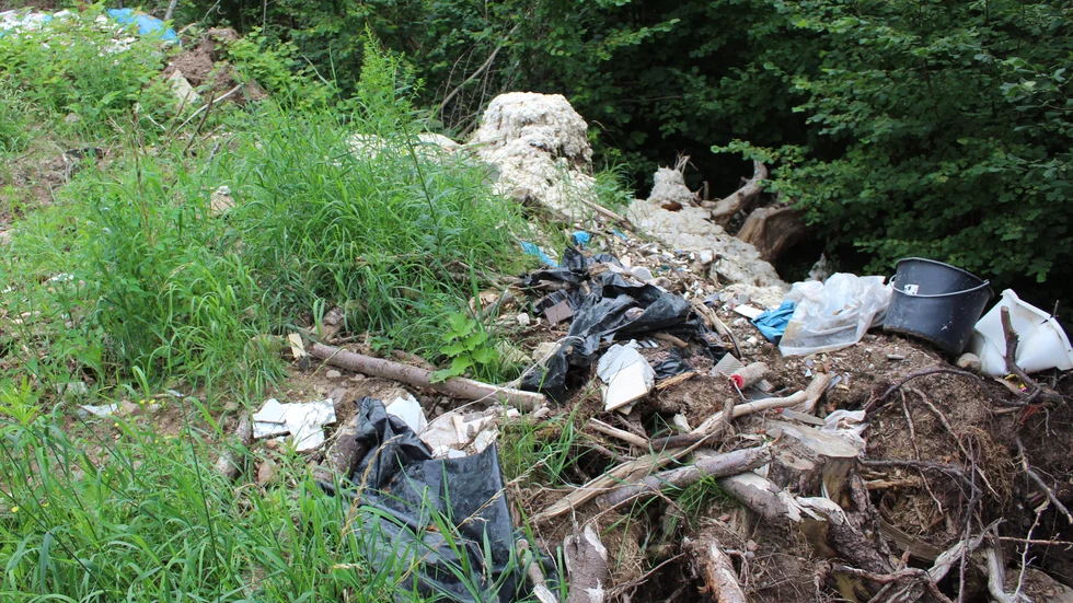I ett skogsbryn utanför Boxholm har någon dumpat bygg- och rivningsavfall i naturen.