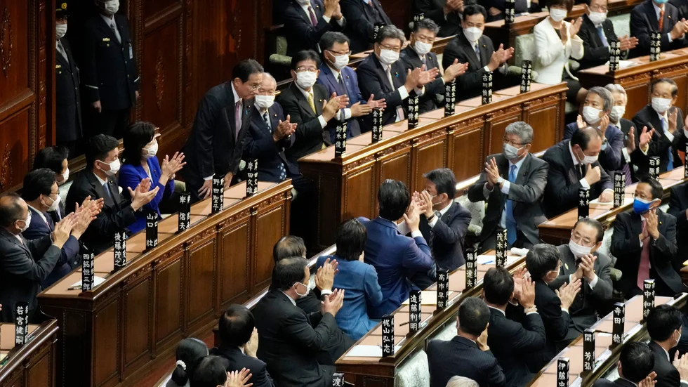 Japans premiärminister Fumio Kishida vid den övre radens mitt bugar efter att ha valts om i parlamentets underhus.