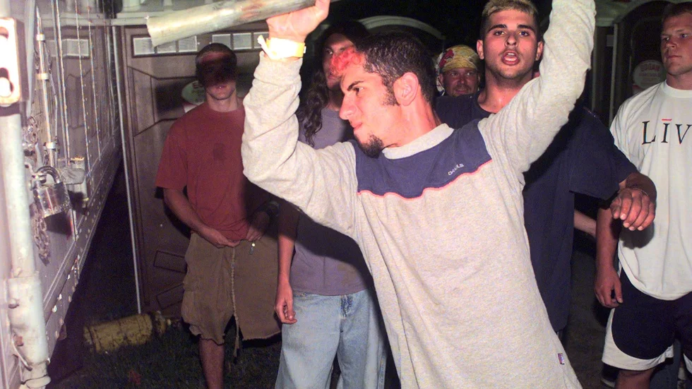 En ung man använder ett rör för att bryta sig in i en lastbil parkerad på campingområdet under den sista dagens upplopp på festivalen Woodstock 99. Den nya HBO-dokumentären "Woodstock 99: Peace, love and rage" undersöker festivalen på djupet. Arkivbild.