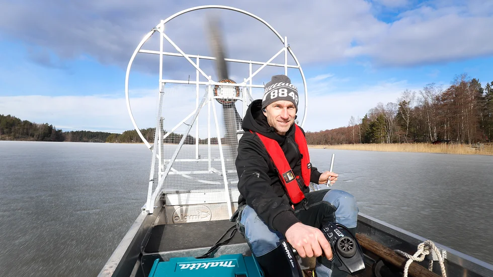  Med en smal roderspak i ena handen och en radiokontroll i den andra manövrerar John de Hosson säkert sin hydrokopter över den isbelagda fjärden.