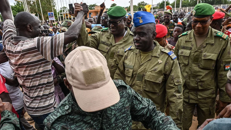 Några av juntaledarna i Niger hälsas välkomna av en folkmassa i huvudstaden Niamey i söndags.