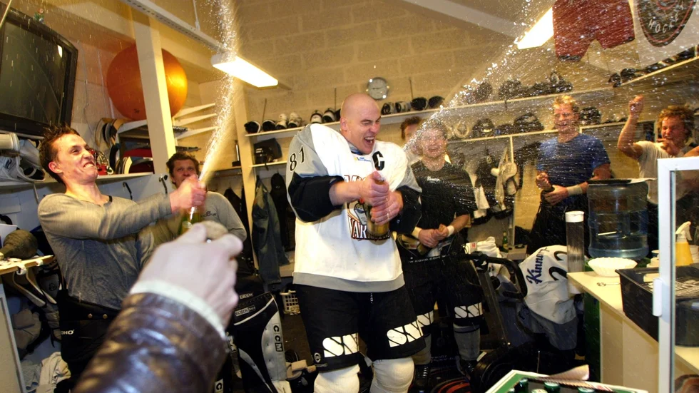 Daniel Jardemyr, i mitten, drar igång firandet i omklädningsrummet i samband med avancemanget till hockeyallsvenskan.