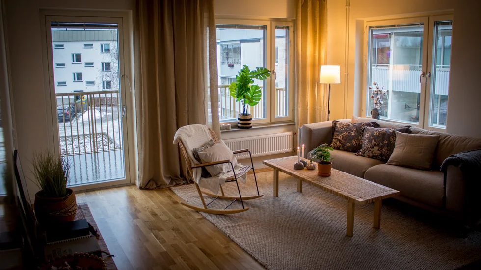 Den inredda visningslägenheten är en trea på hörnet med öppen planlösning mellan kök och vardagsrum och en stor balkong. 