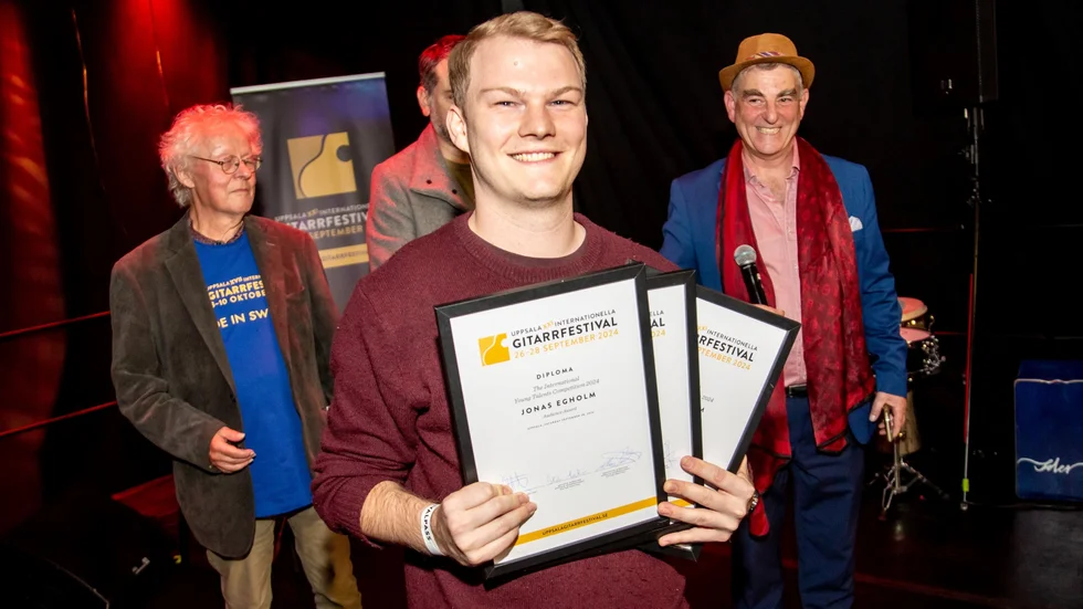 Jonas Egholm tog hem förstapriset i Young talent competition. Bakom honom ses Stefan Löfvenius och Klaus Pontvik från Uppsala internationella gitarrfestival.