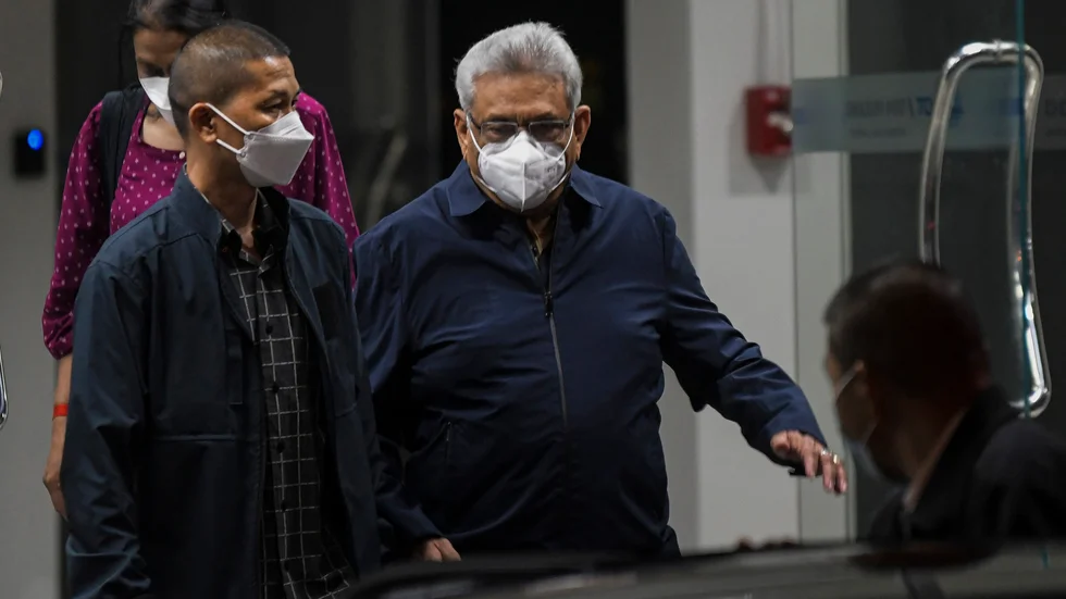 Sri Lankas tidigare president Gotabaya Rajapaksa, i mitten, medan han befann sig i exil i Thailand. Nu har han återvänt till sitt hemland. Arkivbild.