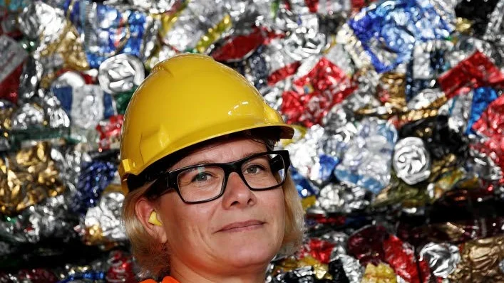 Sara Riismark vid en bal med ihoppressade aluminiumburkar, som väger ungefär ett halvt ton.