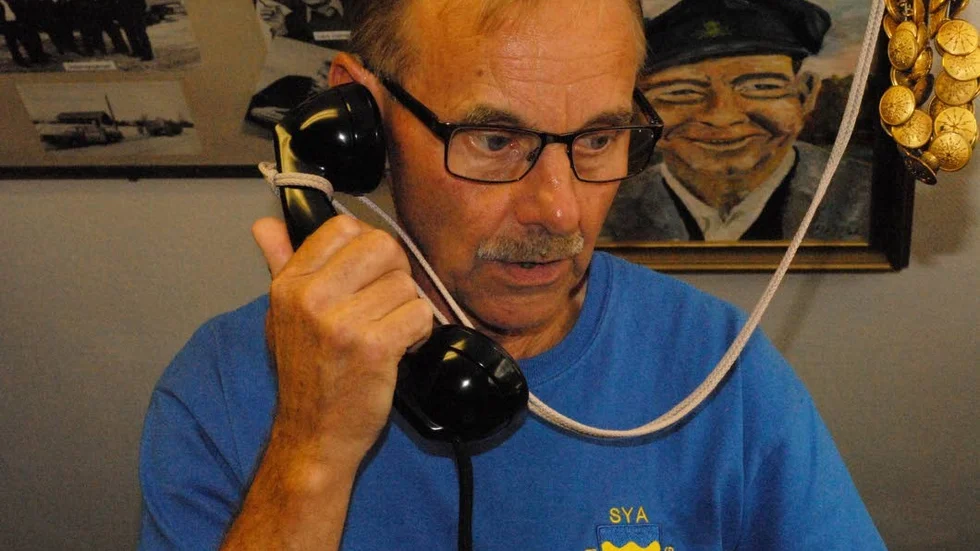 Christer Svensson demonstrerar för turisterna hur man ringer med en gammal telefon från 30- och 40-talet. Sya Hembygdsgård har en omfattande telefonsamling i ett av deras museer.