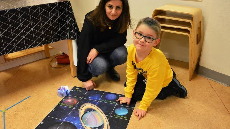 Hugo Olofsson, 7, får hjälp av Roya Saydo att programmera robotar innan de skickas iväg till en bestämd planet.