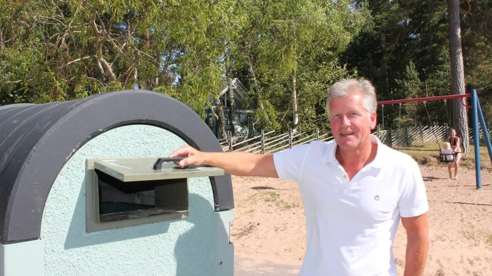 "Här ska folk kasta sitt skräp", säger Thomas Martinsson och håller upp luckan till en av de många containrar som finns i Varamon.