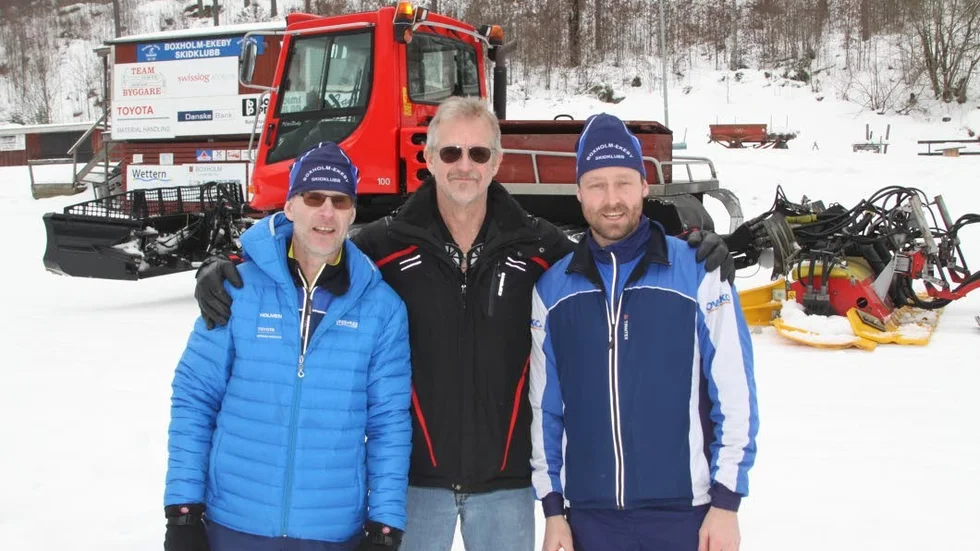 Boxholms skidstadion. Carl Trygger-stiftelsens ordförande Michael Blomqvist håller om skidklubbens Roger Berggren och Daniel Johansson. MIchael tycker att klubben med allt sitt ideella slit är väl värd den nya pistmaskinen.