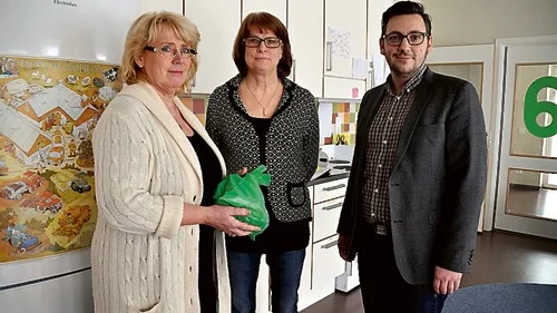 Miljöminister Lena Ek håller nöjt upp en av Hjulsbro-förskolans gröna påsar bredvid Lena Allard och Muharrem Demirok.