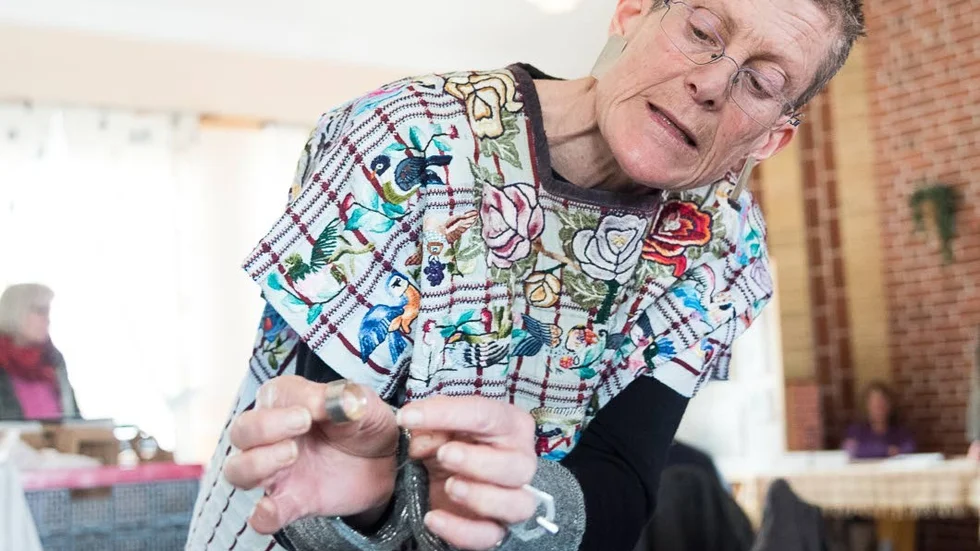 Silversmed. Lena Sjöman visar en detalj på ett silversmycke.